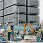 米国のAI革命で技術系職人の需要が増加しホワイトカラーとの力関係が変化する様子を描いた現代日本の都市の建設現場。