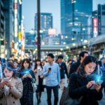 金融庁が「ミュトス」悪用に備え金融機関へ緊急対応を要請。現代日本の都市生活の一コマを表現した画像。