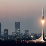 スペースXが次世代スターシップの打ち上げに成功し輸送能力を4倍に向上を示す都市の夜景とロケット発射の様子。